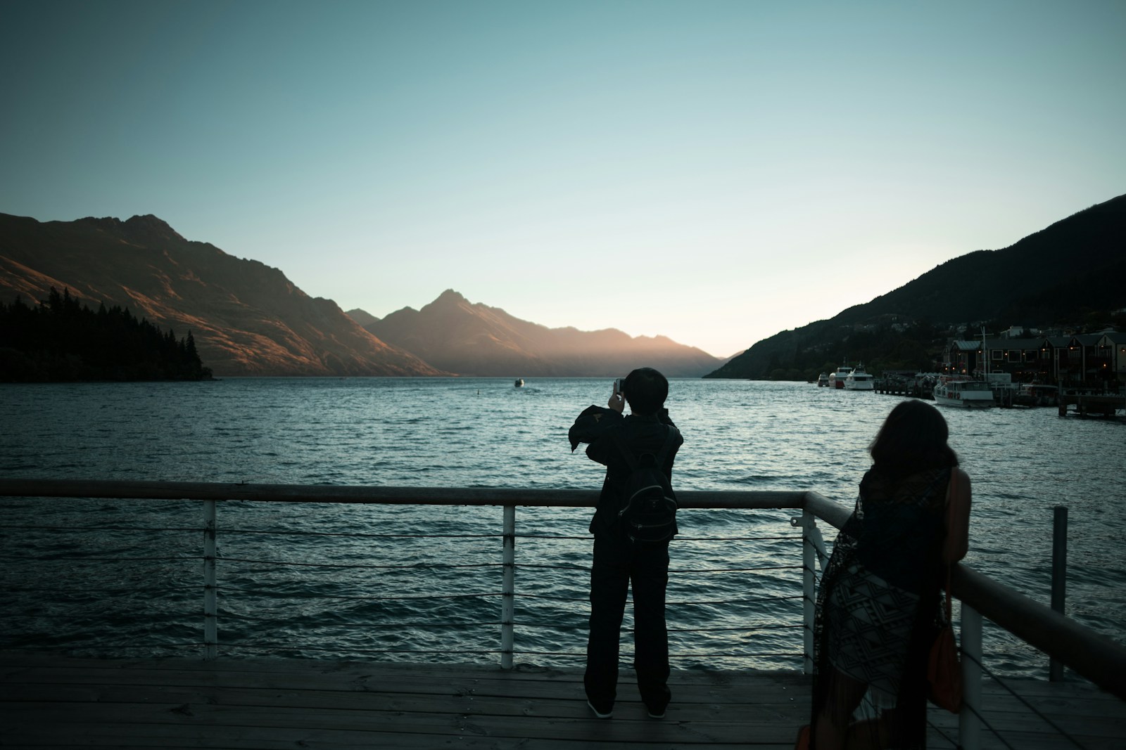 Couple at a Queenstown lakefront viewpoint at golden hour